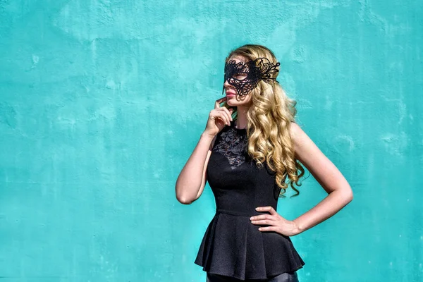 Ragazza con una maschera nera. Colorato sfondo blu tourqoise — Foto Stock