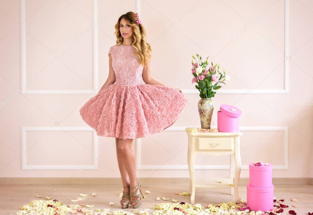 Happy Beautiful blonde girl in a pink dress. Baby doll style. Soft portrait