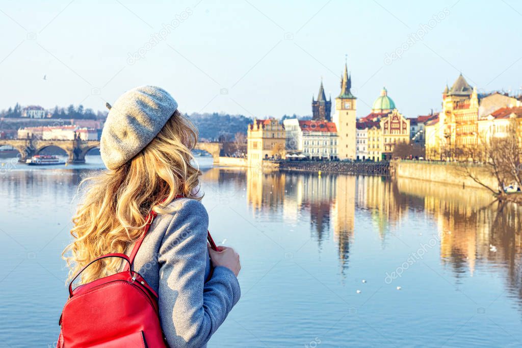 Tourist girl dicovering Prague, Czeh Republic. Charles bridge view on background. Beauty city scape