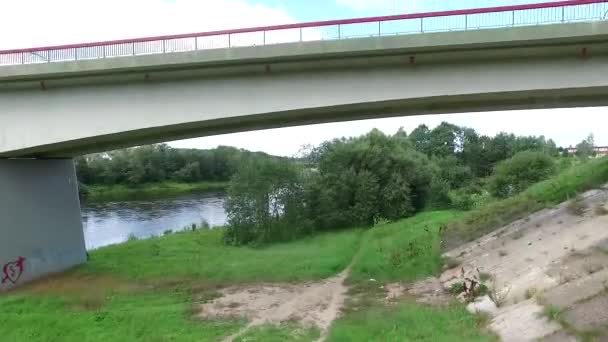 Over de brug in de buurt van de rivier en de stad In afstand oprijzen — Stockvideo