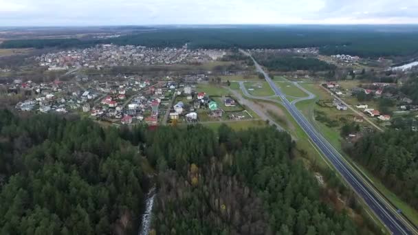 Vuelo sobre el bosque y la ciudad en la distancia — Vídeo de stock