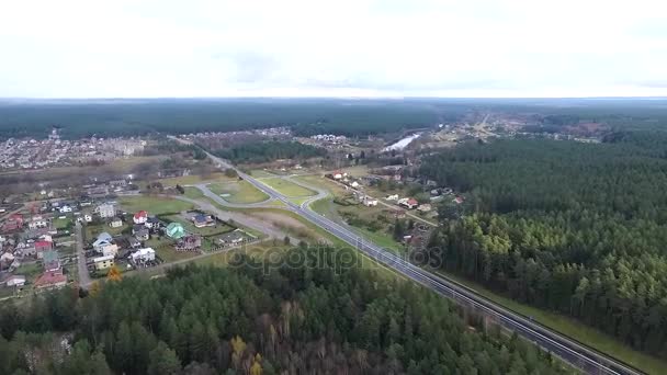 Vuelo sobre el bosque y la ciudad en la distancia — Vídeo de stock