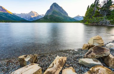 Swiftcurrent Gölü 'nde güzel bir manzara. Çok Buzul Bölgesi' nde güneş doğduğunda Montana 'daki Buzul Ulusal Parkı, Montana, ABD.