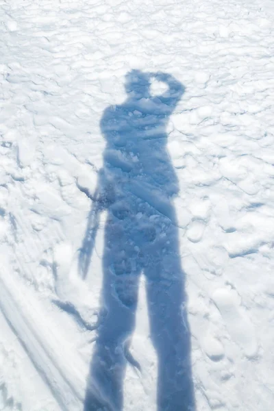 shadow of the  man while photography on the snow.