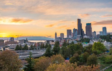 Seattle siluetleri ve eyaletler arası otoyollar Elliott Körfezi ile birleşir ve günbatımı saatinin liman önü, Seattle, Washington State, ABD..