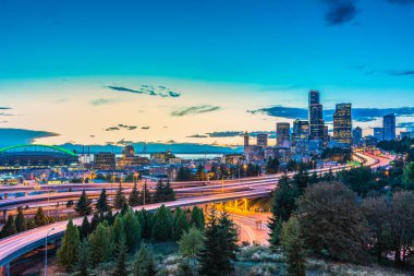 Seattle siluetleri ve eyaletler arası otoyollar Elliott Körfezi ile birleşir ve günbatımı saatinin liman önü, Seattle, Washington State, ABD..