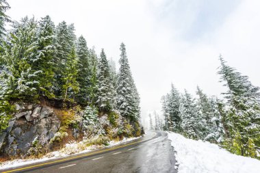 Empty road to the mountain with snow covered landscape in winter season. . clipart