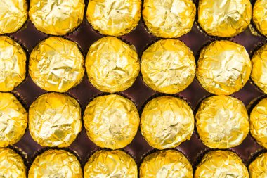 Beyaz arka planda bir sürü parlak çikolata ambalajı var...