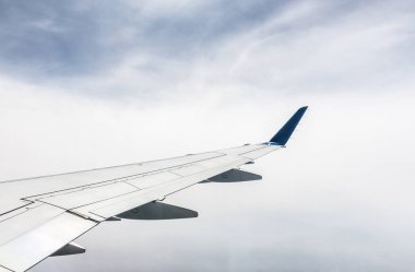 Bulutlu gökyüzünde uçak kanadı manzarası.