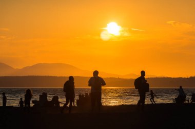 Yazın, Seattle, ABD 'de, gün batımında, plajdaki siluet insanların manzarası..