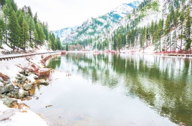 Kışın gölde yansıyan kar dağı..