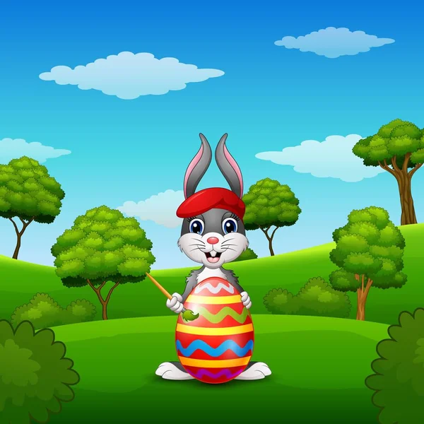 Conejo de Pascua pintando huevos de Pascua en el parque — Vector de stock