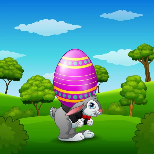 Conejo de Pascua de dibujos animados que lleva huevos de Pascua en el parque — Vector de stock