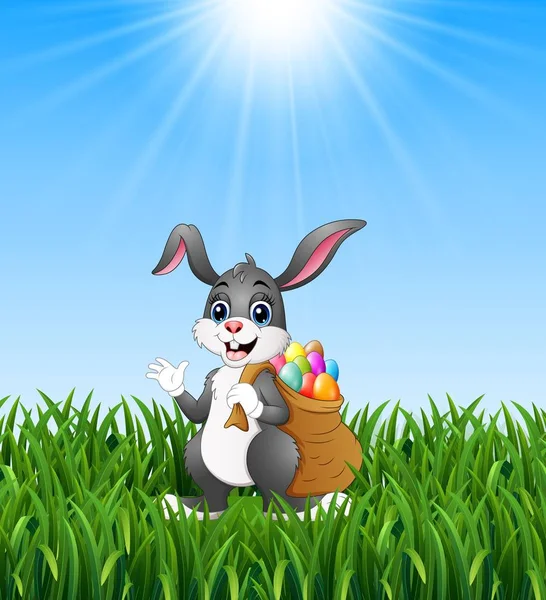 Conejo de Pascua conejo con huevos de Pascua un saco de lleno en el fondo de hierba — Vector de stock