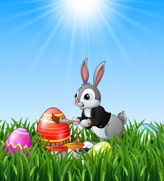 Conejo de Pascua pintura huevos de Pascua en el fondo de hierba — Vector de stock
