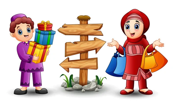 Мусульманська хлопчик мультфільм проведення подарунковій коробці з мусульманським дівчинка тримає покупки сумка — стоковий вектор