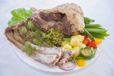 Bir tabakta sebze ile ortaya konulan haşlanmış koyun eti.
