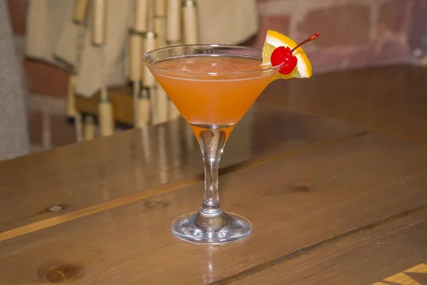 Πορτοκάλι κοκτέιλ σε ένα ποτήρι σε ένα μακρύ μίσχο. — Φωτογραφία Αρχείου