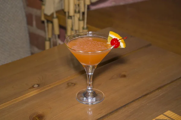 Πορτοκάλι κοκτέιλ σε ένα ποτήρι σε ένα μακρύ μίσχο. — Φωτογραφία Αρχείου