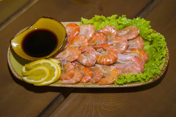 Crevettes appétissantes sur une assiette tapissée de laitue . — Photo