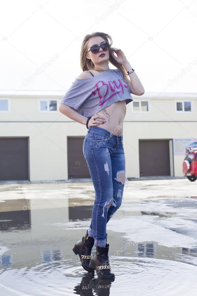 Beautiful young girl posing near the garage.