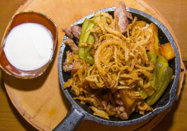 Domuz eti ve soğan ile kızarmış patates.