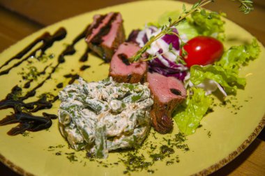 Kızarmış et yeşil fasulye salatası ile devam eder.