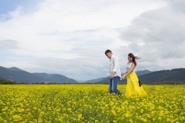 Aşık erkek ve kadın çiçek sahada yürümek.