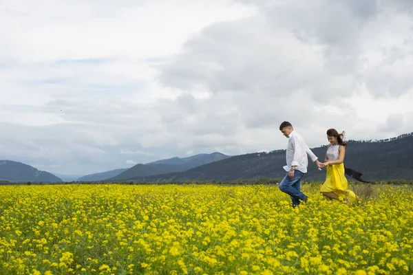Λάτρεις του άνδρα και της γυναίκας με τα πόδια στο πεδίο λουλούδι. — Φωτογραφία Αρχείου