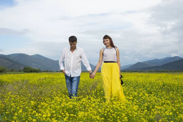 Любителі чоловіка і жінки ходять на квітковому полі . — стокове фото