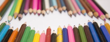 Çok renkli kalemler ve bir beyaz kağıt.