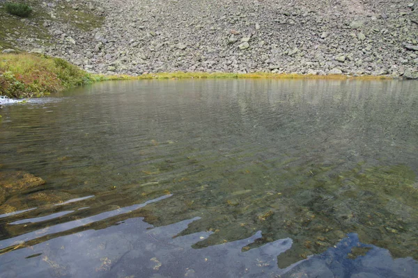 Hermoso lago de montaña rodeado de impresionantes montañas de th —  Fotos de Stock