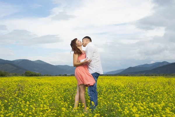 Liefhebbers van man en vrouw lopen op het gebied van de bloem. — Stockfoto