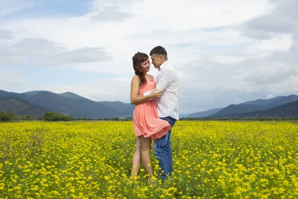 Älskare man och kvinna gå på fältet blomma. — Stockfoto