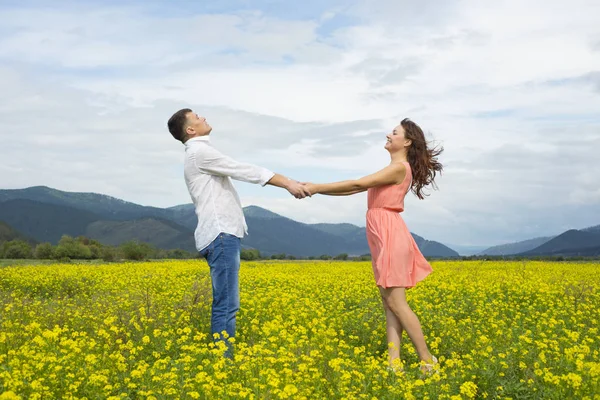 Älskare man och kvinna gå på fältet blomma. — Stockfoto