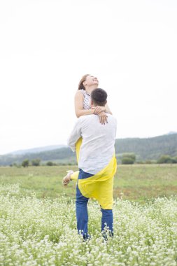 Aşık erkek ve kadın çiçek sahada yürümek.
