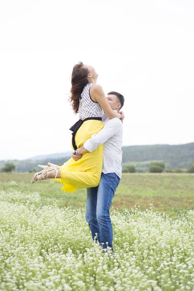 Lovers man and woman walk on the flower field. — Stock Photo, Image
