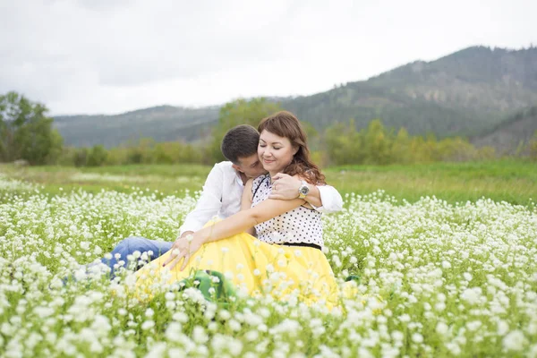 Los amantes se encuentran con hombres y mujeres en un hermoso campo de flores . —  Fotos de Stock