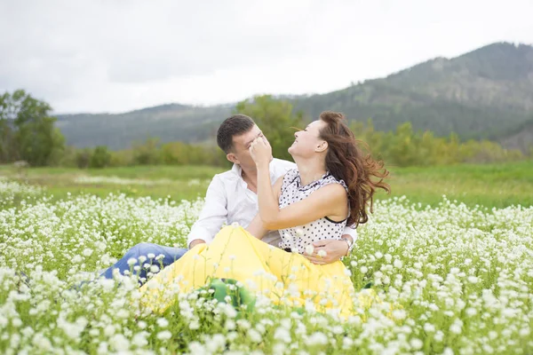 Los amantes se encuentran con hombres y mujeres en un hermoso campo de flores . — Foto de Stock