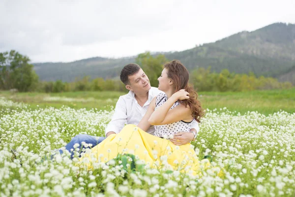 Szerelmesek felel meg a férfiak és nők egy gyönyörű virág mező. — Stock Fotó