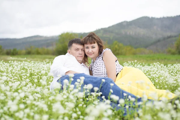 Los amantes se encuentran con hombres y mujeres en un hermoso campo de flores . —  Fotos de Stock