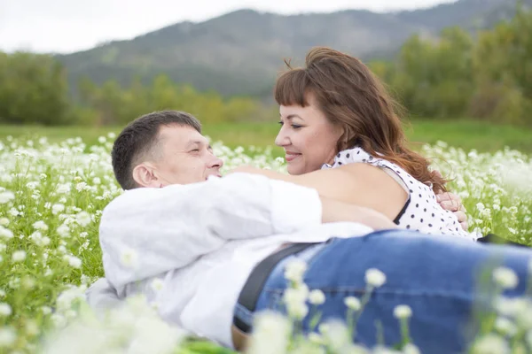 Os amantes conhecer homens e mulheres em um belo campo de flores . — Fotografia de Stock