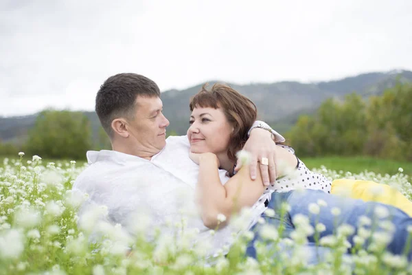 Любовники встречают мужчин и женщин на красивом цветочном поле . — стоковое фото