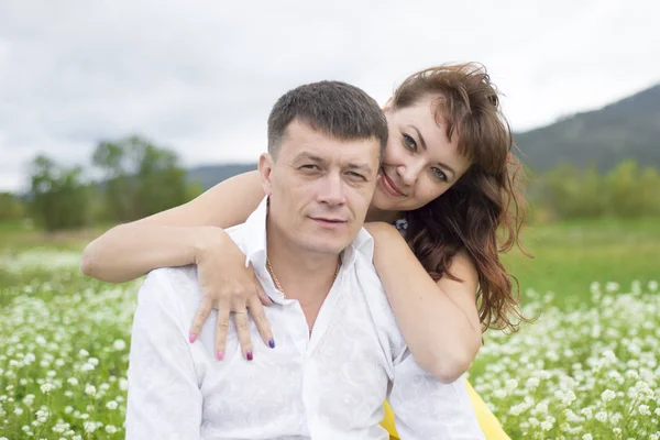 Os amantes conhecer homens e mulheres em um belo campo de flores . — Fotografia de Stock