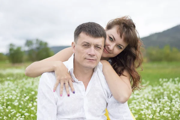 Los amantes se encuentran con hombres y mujeres en un hermoso campo de flores . —  Fotos de Stock