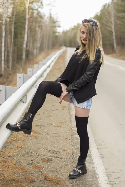 Beautiful young girl corrects stockings. — Stock Photo, Image