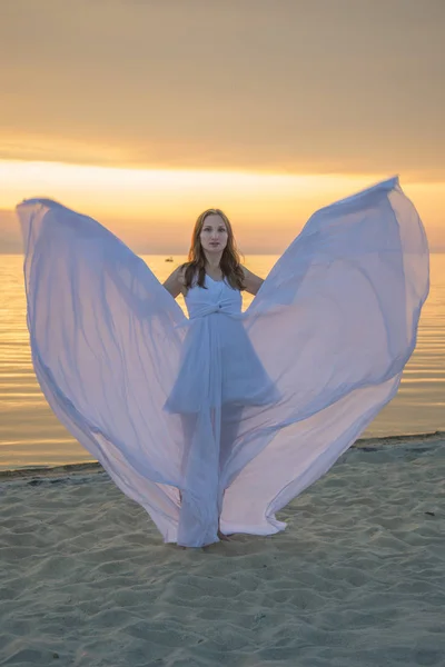 Piękna dziewczyna w długiej, białej sukni, spacery nad morzem. — Zdjęcie stockowe
