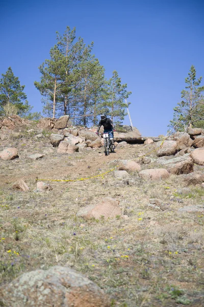 Ulan-Ude, Rusia - 27 de abril: Corredor desconocido en la competición por la "Copa de Buriatia en una bicicleta de montaña" lleva la bandera de la empresa "GT" el 27 de abril de 2014 en Ulan-Ude, Rusia . — Foto de Stock