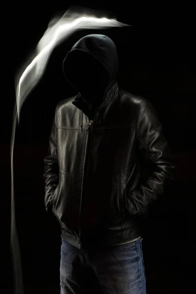 Místico preto encapuzado homem de pé no escuro . — Fotografia de Stock