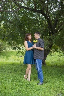 Aşık erkek ve kadın bir yapraklı ağaç gölgesinde standı.